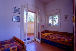 a bedroom with two beds and a sliding glass door at Dalle Grotte al Mare in Fontane Bianche