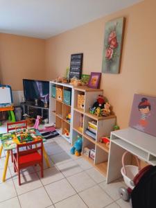 a toy room with a table and a tv at Maison familiale EXCELLENCE,3 chambres jardin avec jeux, proche gare Bourg en Bresse in Saint-Denis-lès-Bourg