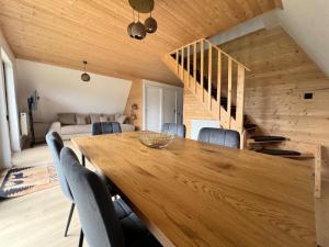 a dining room with a wooden table and chairs at Crow's Nest Maguri in Măguri