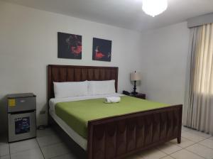une chambre avec un grand lit avec une couverture verte dans l'établissement Kartagus Centric, à San Salvador 18 autres photos