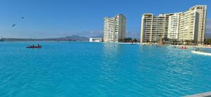 ein großer Pool mit blauem Wasser vor den Gebäuden in der Unterkunft Departamento Laguna del Mar in La Serena + 18 Fotos