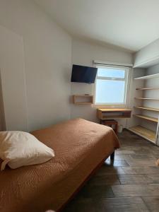 a bedroom with a bed and a desk and a window at Privada 400 in Pachuca de Soto