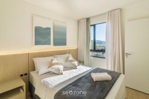 a bedroom with a bed with a large window at Estadia completa com piscina e academia a 400m da Praia da Armação - SKL in Penha +157 photos