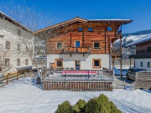 a log house in the snow with a fence at Chalet Kirchberg L in Kirchberg in Tirol