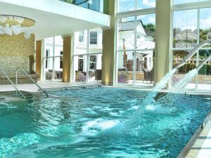 a swimming pool with a fountain in a building at Bedford Lodge Hotel & Spa in Newmarket
