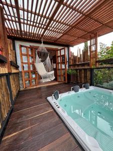 a patio with a hammock and a hot tub at Glamping Montesereno in El Peñol +8 photos