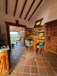 a living room with a table and chairs and a patio at Glamping Montesereno in El Peñol