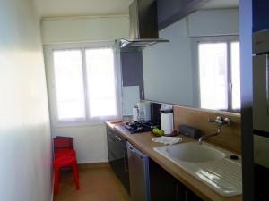 a kitchen with a sink and a red stool at Themis by Welcome to Cannes in Cannes