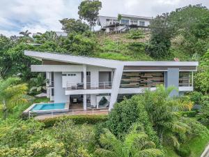 a house on a hill with a swimming pool at Luxury Villa Los Pajaros Private Pool & Oceanview in Playa Hermosa