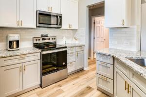 a kitchen with white cabinets and stainless steel appliances at 9 Mi to College Station Dog-Friendly Home with Yard in Bryan