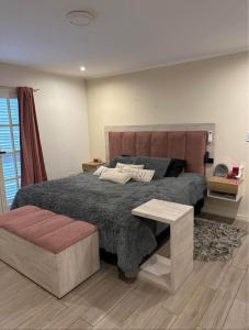 Un dormitorio con una cama grande y una mesa. en Casa Quinta, en Necochea