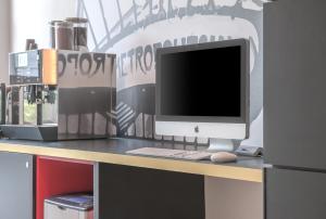 un bureau avec un moniteur d'ordinateur, un clavier et une souris dans l'établissement Citadines Tour Eiffel Paris, à Paris