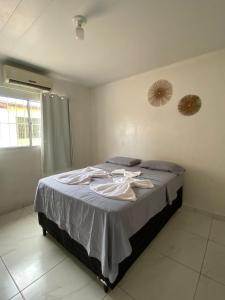 a bedroom with a bed with clothes on it at Pousada Japaratinga Good Vibes in Japaratinga