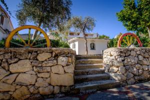 a stone wall with two water wheels and a house at Dalle Grotte al Mare in Fontane Bianche