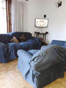 a living room with a blue couch and a table at Exclusivo chalet a 250 metros del mar in Mar de Ajó