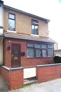 a brick house with a brown door and windows at Beautiful 5Bedroom House - Contractors and Family near the Molineux stadium in Wolverhampton