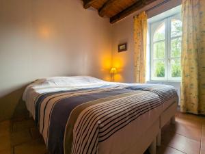 a bed in a bedroom with a large window at Maison de vacances en Brenne avec piscine partagée, grand jardin et tout confort inclus - FR-1-591-329 in Bélâbre
