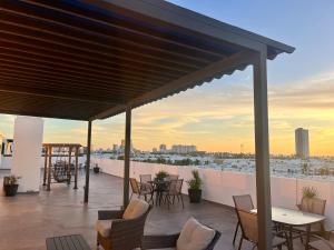 eine Terrasse mit Tischen und Stühlen auf einem Dach in der Unterkunft Loft de lujo con 9 albercas y vistas al campo de golf in Mazatlán + 8 Fotos
