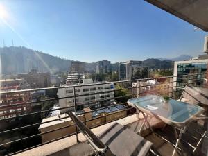 a balcony with a table and chairs and a view at Comodo departamento en Pedro de Valdivia in Santiago