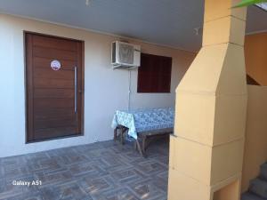 a room with a door and a bench with a window at Apartamento térreo fundos in Torres