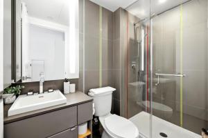ein Badezimmer mit Toilette, Waschbecken und Dusche in der Unterkunft Modern Studio Retreat in Downtown Toronto in Toronto
