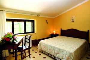 um quarto com uma cama, uma secretária e uma mesa em Il Nibbio Reale Country House em Rocca dʼEvandro