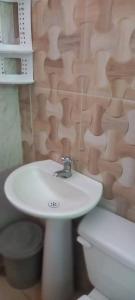 Un baño con lavabo blanco y inodoro. en DLuchy Casa Finca Rural cerca al mar, en San Bernardo del Viento