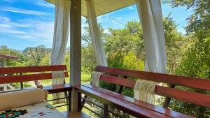 eine Veranda mit einer Bank und Blick auf die Bäume in der Unterkunft Boho-Vibes with Soft Beds, Cozy Balconies and Sport equipment in Haad Pleayleam