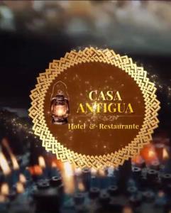 a logo for a hotel and restaurant with a city in the background at Hotel y Restaurante Casa Antigua in San Antonio Suchitepéquez