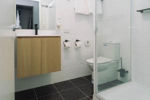 a bathroom with a toilet and a sink at 429 Apartments & Suites in Hobart