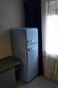 ein blauer Kühlschrank in einer Küche neben einem Fenster in der Unterkunft Естетична квартира для тих хто любить комфорт, подобово в Вінниці in Winnyzja