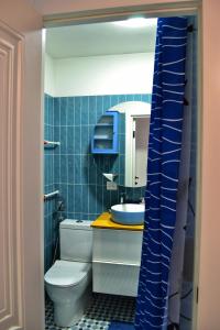 ein blau gefliestes Badezimmer mit Toilette und Waschbecken in der Unterkunft Естетична квартира для тих хто любить комфорт, подобово в Вінниці in Winnyzja