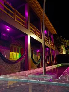 a building with purple lights on the side of it at PANORÂMIC LUXO EXCLUSIVe in Santa Cruz Cabrália +41 photos