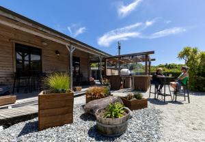 a woman sitting at a table on a patio at Punakaiki Rocks Hotel & Garden Bar in Punakaiki +7 photos