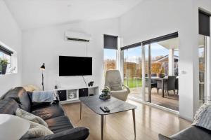 a living room with a couch and a tv at OH534-Hadsund-Haslevgarde-Eng-2 in Hadsund