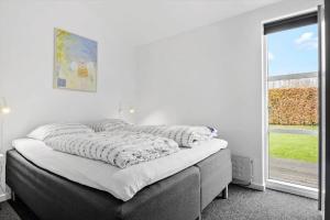 a bed in a room with a large window at OH534-Hadsund-Haslevgarde-Eng-2 in Hadsund