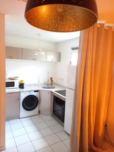 a kitchen with a washer and dryer at Lagoon Studio Plage in Schœlcher