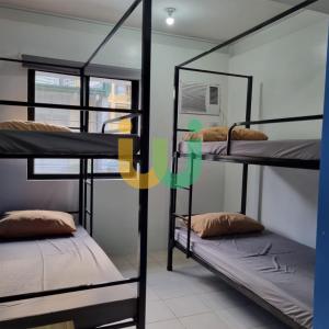 two bunk beds in a room with a window at Woke Coliving Kanlaon in Manila