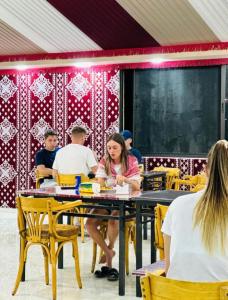 a group of people sitting at tables in a restaurant at RUM FLORAA LUXURY CAMp in Wadi Rum