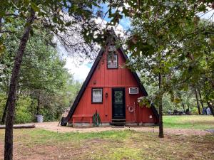 a red barn with a black roof at Timber Haven - Cozy A-frame Hot Tub Fireplace in Friendship