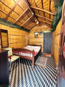 a bedroom with a bed and a chair in a room at Hampi's Dream Cottage in Hampi +25 photos