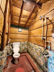 a bathroom with a toilet in a wooden structure at Hampi's Dream Cottage in Hampi