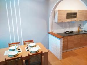 a dining room with a table and a kitchen at Apartment Premija in Vrdnik