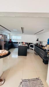 a large kitchen with black counters and a white floor at Casa para Cop 30 in Belém