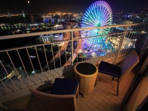 a balcony with chairs and a ferris wheel at night at The Yokohama Bay Hotel Tokyu in Yokohama