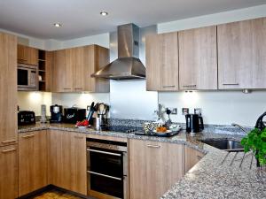 a kitchen with wooden cabinets and a sink at Harbreck Heights -Masts B9 in Torquay