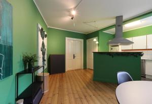 a living room with green walls and a table and chairs at Green Brook Family 4-6 PAX in Aalborg