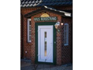 a brick building with a white door and a sign at One-bedroom apartment in Prerow