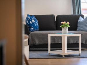 a white table with a potted plant on it in a living room at One-bedroom apartment in Prerow +3 photos