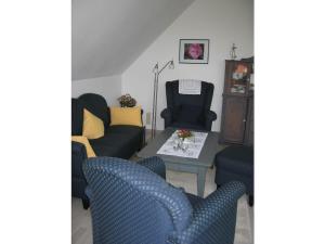 a living room with three chairs and a table at One-bedroom apartment in Heiligenhafen
